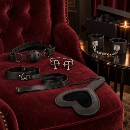 Coffret BDSM intermédiaire avec bâillon, pinces, collier, paddle et bracelets – mise en scène d'ambiance (image générée par IA)
